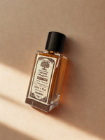 Flacon Sijilmassa parfum boisé et épicé sur fond désertique.